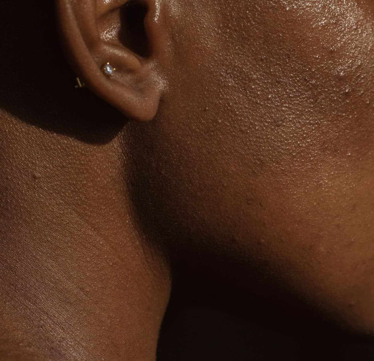 Gros plan d’une nuque et d’une épaule, peau lisse en lumière rasante
