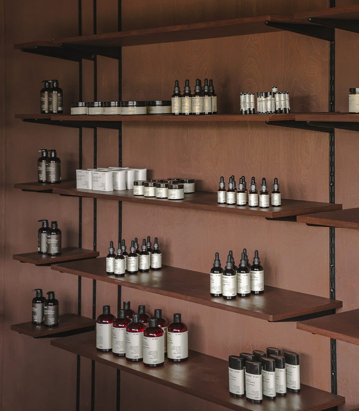 Rayonnages de bois éclairés, garnis de flacons ambrés alignés
